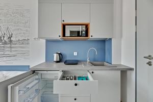 a kitchen with white cabinets and a sink at Apartgdynia in Gdynia