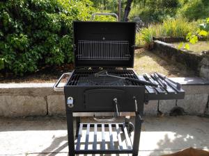 a black grill sitting on a bench in a yard at Počitniška hiša Miklavčič Primorska in Divača