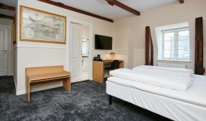 a hotel room with two beds and a desk at Jørgensens Hotel in Horsens +59 photos