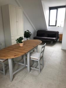 una mesa de madera y sillas en la sala de estar. en B&B Twiske Zuid, Amsterdam free parking en Ámsterdam
