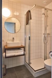 een badkamer met een douche en een wastafel bij Hotel VILLA GROET in Avenhorn