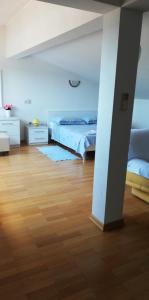 a bedroom with two beds and a wooden floor at ARGUSA4 in Makarska