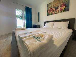 Un dormitorio con una cama con toallas. en Dream Hill Athos, en Ouranoupoli