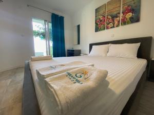 a bedroom with a bed with towels on it at Dream Hill Athos in Ouranoupoli