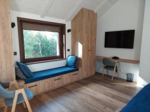 a room with a window and a blue couch at Willa Na Pstrążnicy in Kudowa-Zdrój