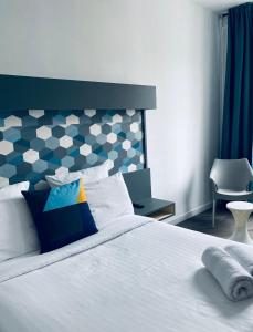 a bedroom with a white bed and a chair at Little Lodge Hôtel in Brest