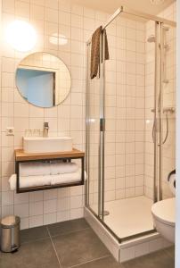 a bathroom with a sink and a shower at Hotel VILLA GROET in Avenhorn