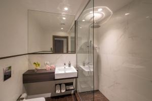 La salle de bains est pourvue d'un lavabo et d'une douche. dans l'établissement Corso Grand Suite, à Rome