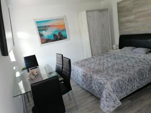 a bedroom with a bed and a glass table at NATA Apartman in Gyula