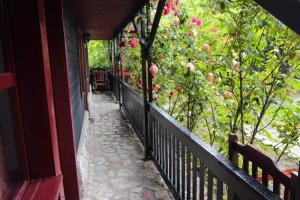 a porch with a fence and pink flowers at C Dor de Vama Bedrooms in Vama Veche