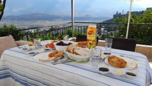 einen Tisch mit Lebensmittelplatten und Aussicht in der Unterkunft Inn Cloud Gjirokaster in Gjirokastër