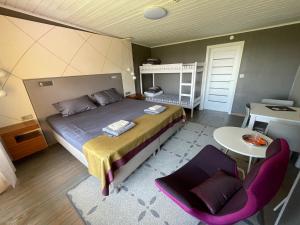 a bedroom with a bed and a table and a chair at Vaibla Holiday Center in Vaibla +37 photos