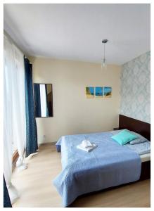 a bedroom with a large blue bed with blue sheets at Lazurowy Dwor in Sztutowo