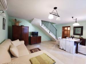 a living room with a white couch and a staircase at Apartments Linda in Drasnice