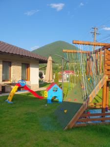 a yard with a playground with a slide and play equipment at Cuibul Visurilor in Măieru