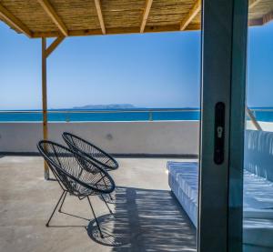 une chaise assise sur un balcon avec vue sur l'océan dans l'établissement Anfi Suites, à Gouves