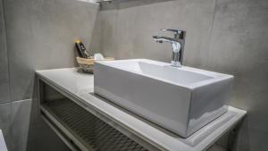 un lavandino bianco su una mensola in bagno di Anfi Suites a Gouves