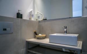 La salle de bains est pourvue d'un lavabo et d'un miroir. dans l'établissement Anfi Suites, à Gouves