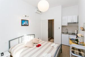 a small bedroom with a bed and a kitchen at Studios IM in Dubrovnik