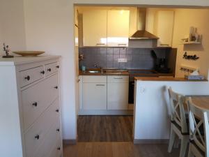 a kitchen with white cabinets and a counter top at Ferienwohnung Alpenspaß in Missen-Wilhams