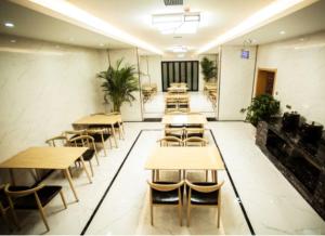 a room with tables and chairs in a restaurant at GreenTree Inn Xi'an Ming City Wall Northwest Dafengqing Road Business Hotel in Xi'an