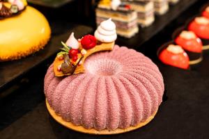 einen rosa Kuchen mit Schlagsahne und Erdbeeren oben in der Unterkunft The Palace Hotel, Sunny Day in Sweti Konstantin