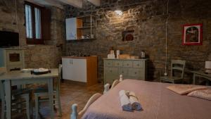 a room with a bed and a table and a kitchen at Il Rifugio di Bomar in Pietrapertosa