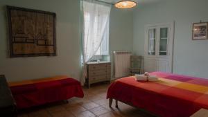 a bedroom with two beds and a dresser and a window at La Via di Fuga in Pietrapertosa