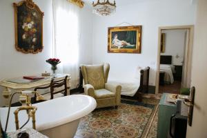 a bathroom with a tub and a chair and a bed at Domus Socolatae Residenza d'Epoca Charming B&B - Adults Only in Follonica