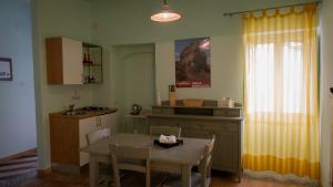a kitchen with a table and a sink and a table and chairs at La Via di Fuga in Pietrapertosa +39 photos