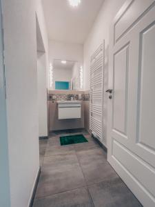 a white bathroom with a sink and a door at Boardinghouse alte Spinnerei in Offenburg