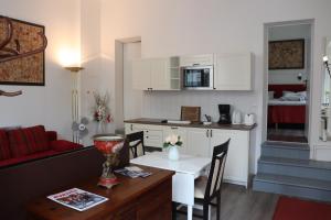 uma cozinha e uma sala de estar com uma mesa e uma cozinha e um quarto em Ferienwohnung Luise em Potsdam