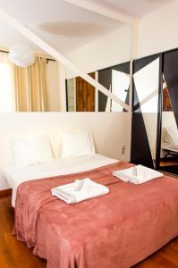 a bed with two white towels on top of it at Bohemian Apartment - Center of Bucharest in Bucharest