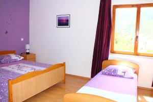 a bedroom with two beds and a window at Apartment Teraferma in Komiža