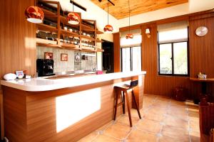 a kitchen with a bar with a counter top at 豐 FONG PENSiON - 無合作 ᴀɢᴏᴅᴀ 平台 in Taitung City