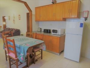 a kitchen with a table and a white refrigerator at Casa S Nicolau 2 Near the beach in Lourinhã