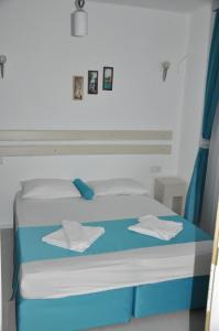 Una cama con sábanas azules y blancas y toallas. en Hotel Nisa, en Kas