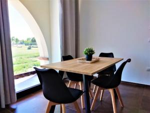 a dining room table with black chairs and a window at Agriturismo Tre di Spade in Savio di Ravenna