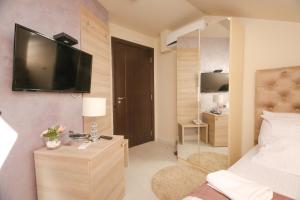 a bedroom with a bed and a television on a wall at Bajadera Lux in Belgrade