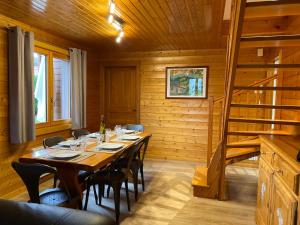 a dining room with a table with chairs and a staircase at Chalet Miel in Gérardmer