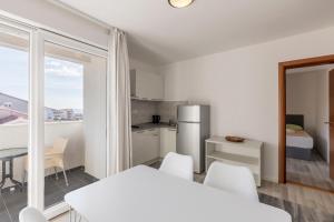 a white kitchen with a table and chairs in a room at Villa Stipe in Podstrana +56 photos