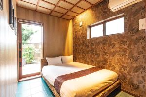 een kleine slaapkamer met een bed en een raam bij Kyobu Higashiyama in Kyoto