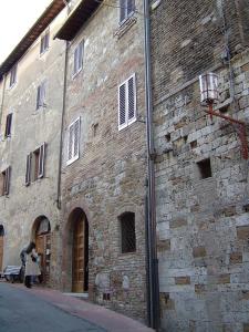 een vrouw die naast een bakstenen gebouw staat bij Antica Posta in San Gimignano