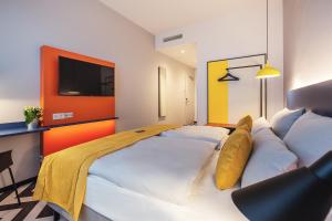 ein Hotelzimmer mit einem großen weißen Bett mit Kissen in der Unterkunft the niu Form in Stuttgart