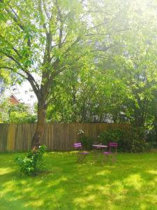 two pink chairs and a table in a yard with a tree at 300 meter walk to LEGO HOUSE - no.18 Great Location in Billund