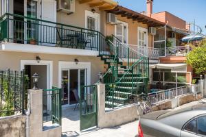 um edifício com escadas verdes numa rua em Joannas Luxury Apartment em Corfu Town
