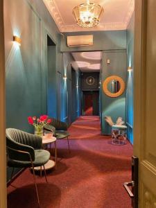 - un couloir avec des chaises, une table et un miroir dans l'établissement Lift Hotel Boutique, à Odessa