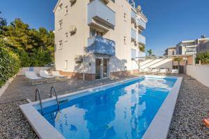 a swimming pool in front of a building at Villa Stipe in Podstrana