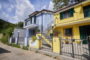 une maison jaune et blanche avec une clôture dans l'établissement Ca' de Paggia, à Savone