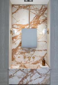 a tv in a room with a marble wall at Kinglin Luxury Living in Athens